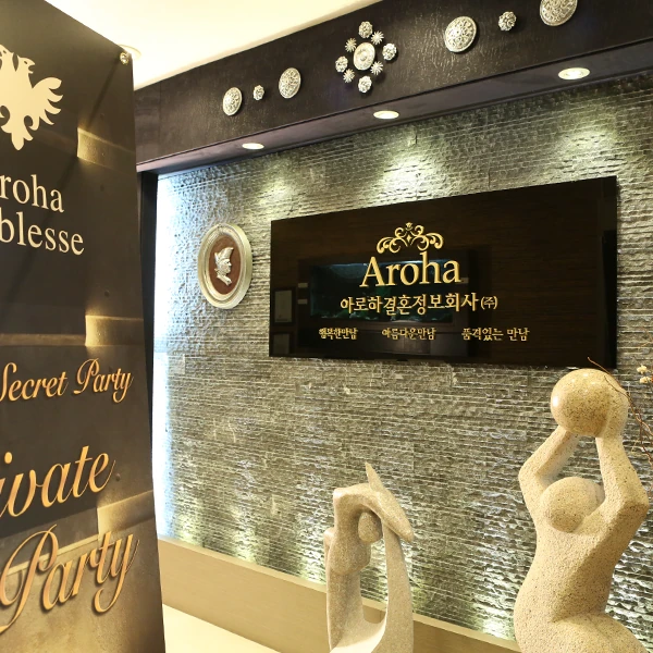 아로하 결혼정보회사 사무실 내부 — Aroha 간판과 조형물이 있는 로비